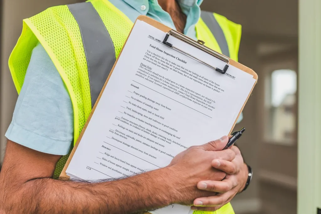 Inspector in a safety vest holding a checklist on a clipboard