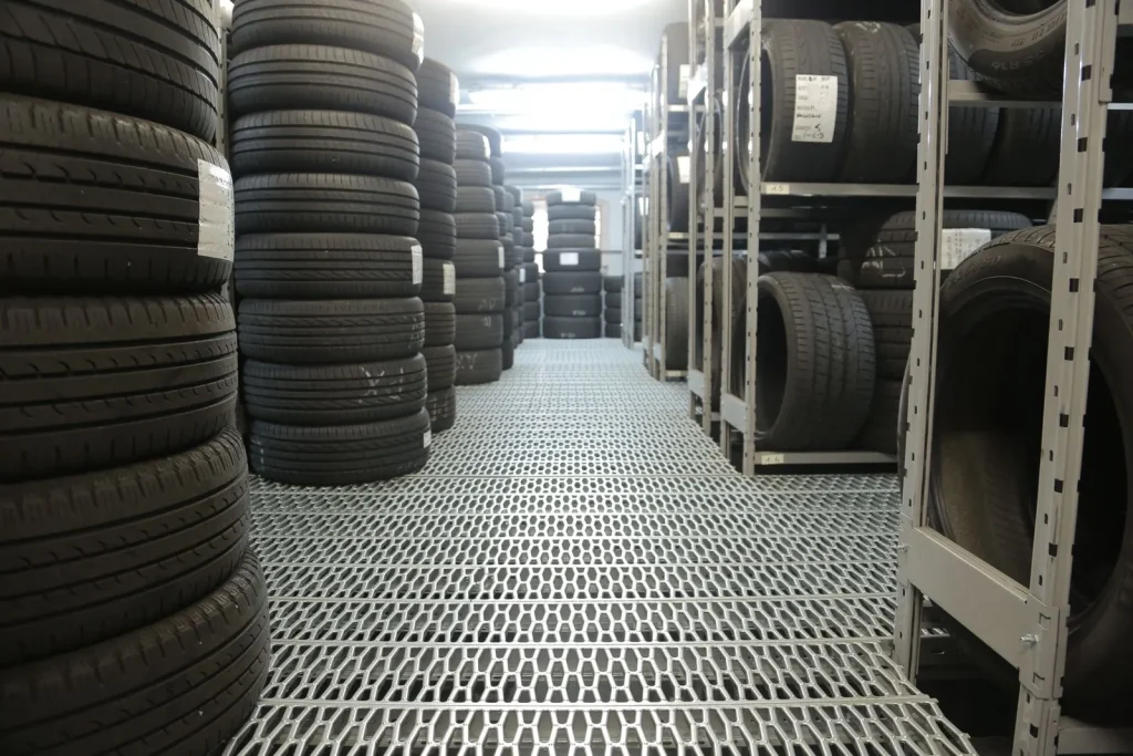 Rows of tyres stored on racks along a warehouse aisle