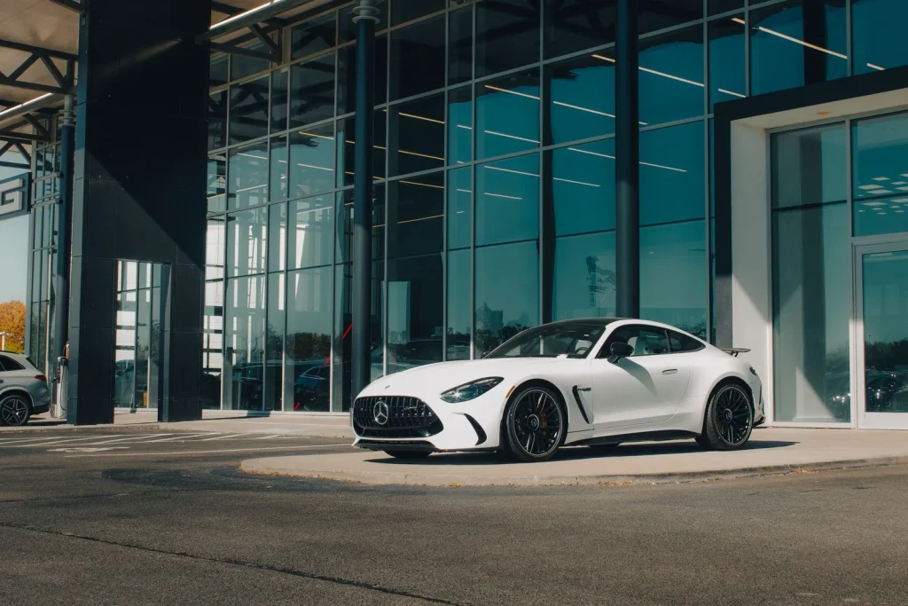 White Mercedes-Benz outside a modern dealership