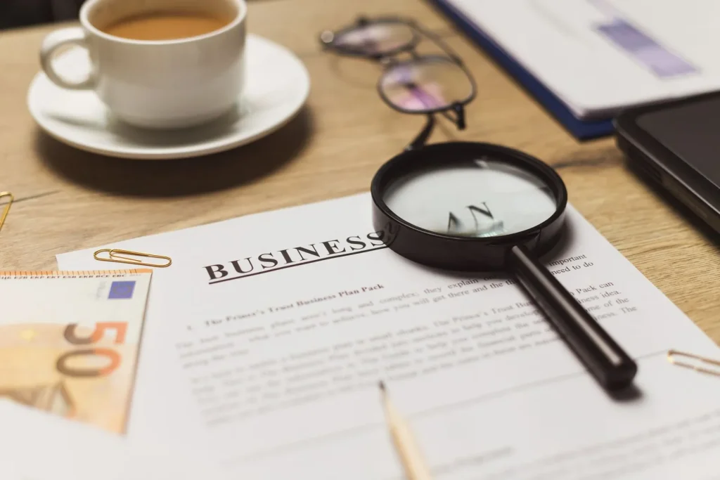 Business documents with a magnifying glass and a cup of coffee
