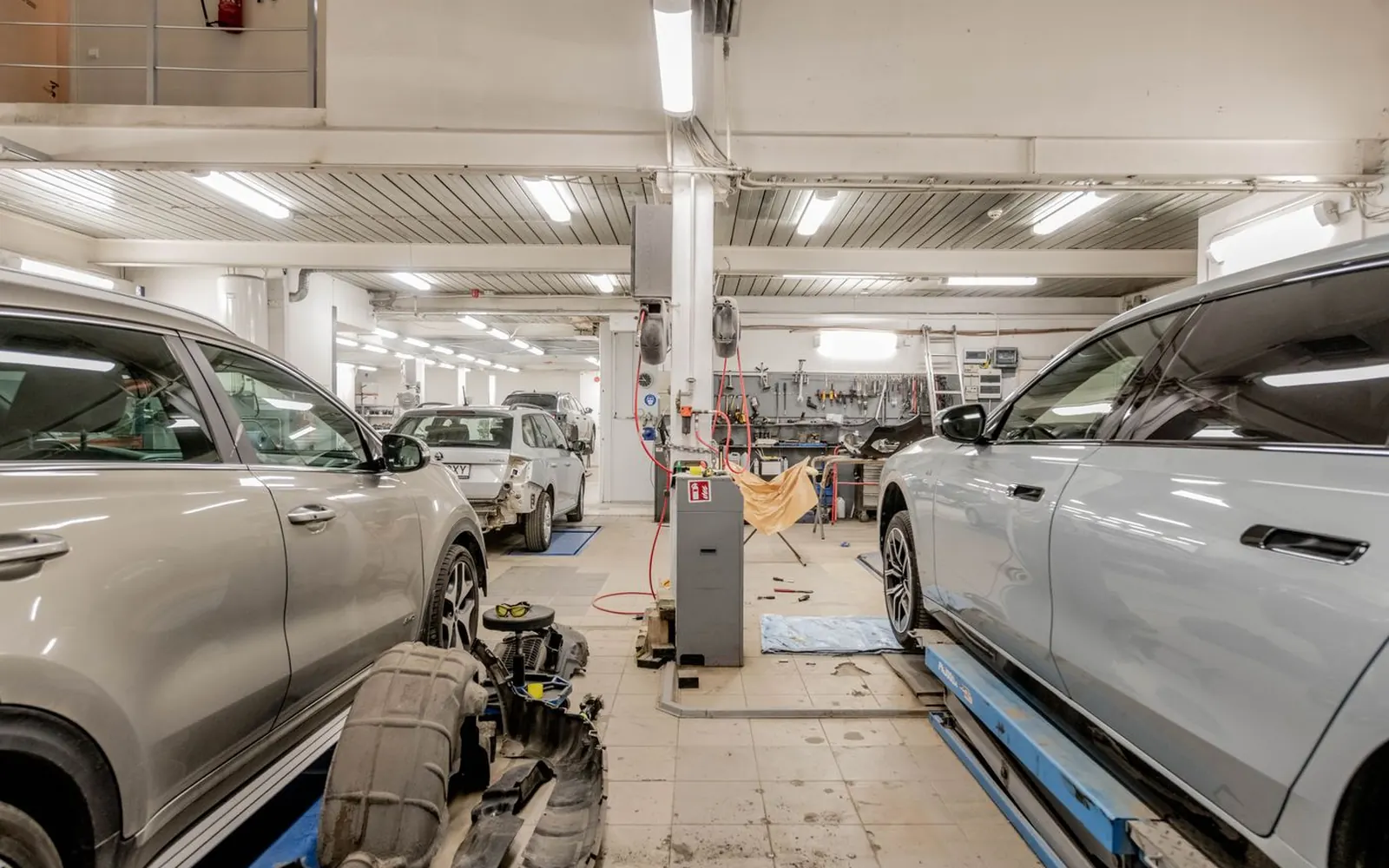 Cars in a bright, modern dealership service workshop